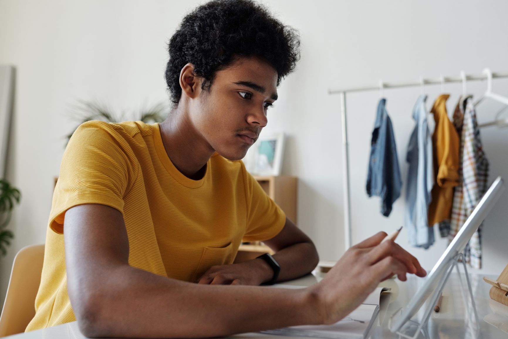 High school graduate at desk, researching student loans online.